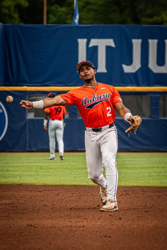 Infielder in orange throwing the ball across the diamond