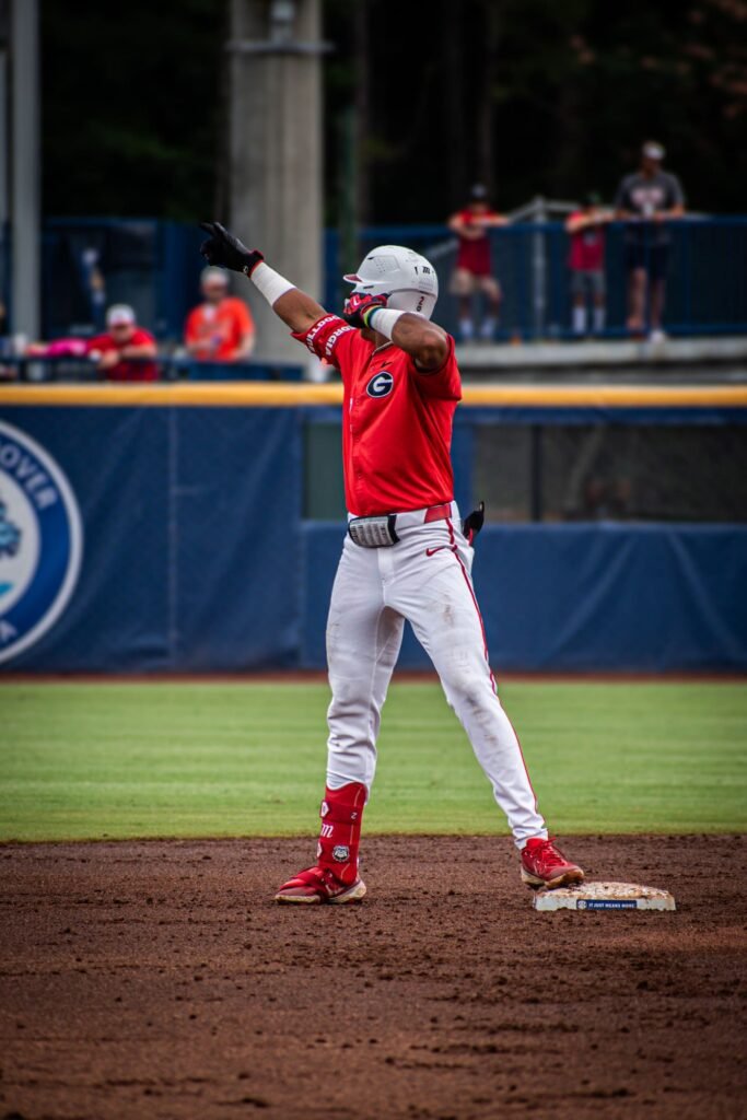 Player in a red jersey pointing to the sky at second base