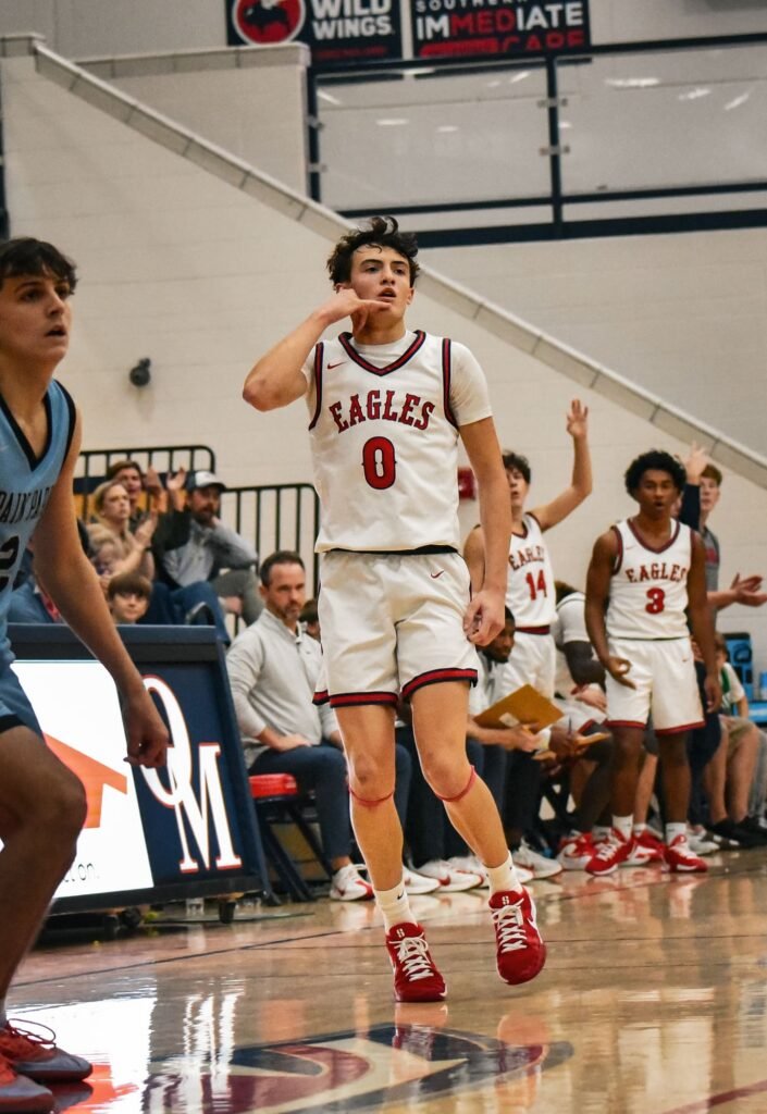 Player in white and red bringing the ball up the court