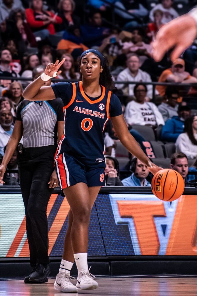 Player in navy number 0 dribbling near the baseline