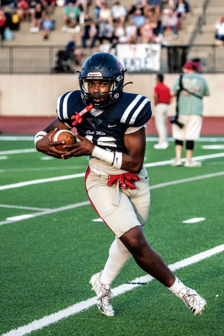 Running back in navy number 12 carrying the ball down the sideline
