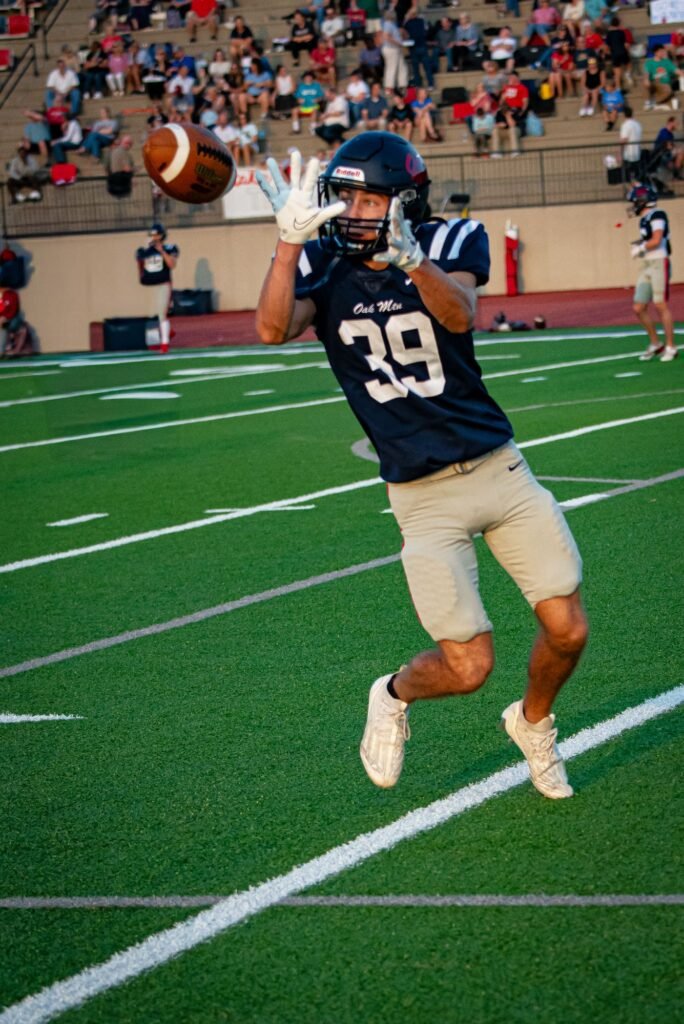 Player in navy number 39 leaping to catch a football on the field