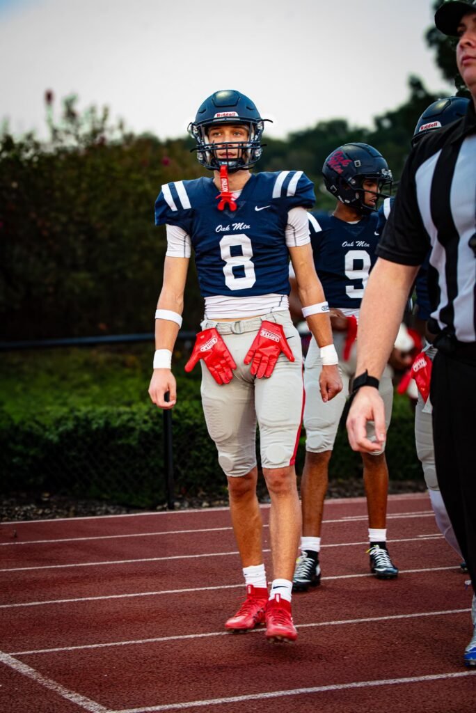Two team captains in navy walking out for the coin toss with an official