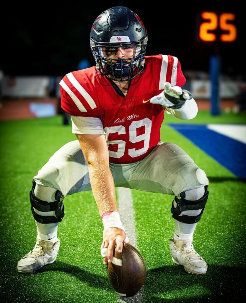 Lineman in a red number 69 jersey crouched over the ball