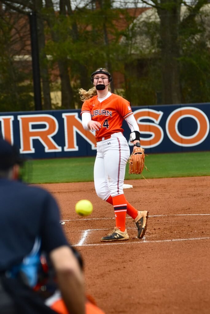 Softball infielder in orange fielding the ball
